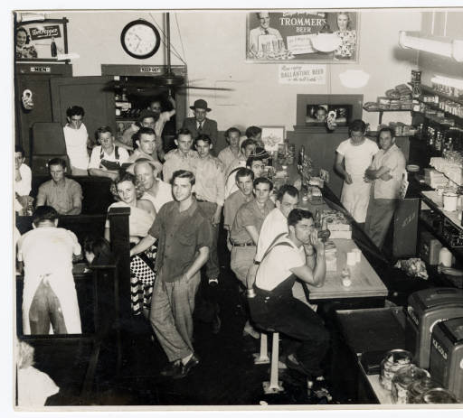 The man behind the counter with his arms crossed is Bill Farris who was the owner.